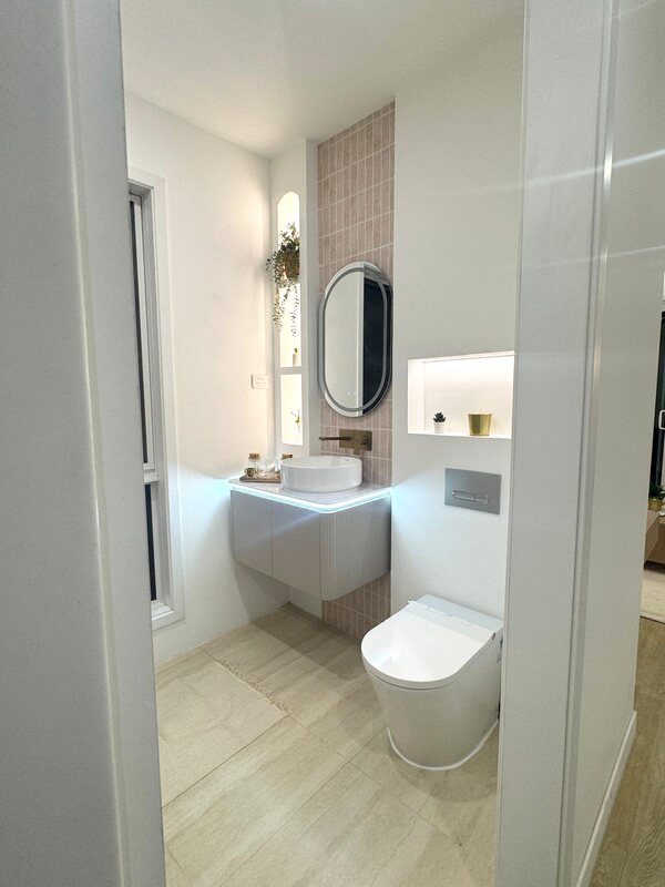 Bathroom with backlit oval mirror and floating vanity